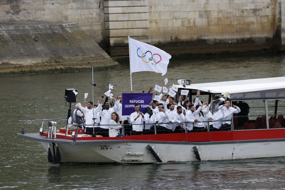 La selección de refugiados bajo la bandera de las olimpiadas desfilan por el río Sena, durante la ceremonia de inauguración de los Juegos Olímpicos de París 2024, este viernes en la capital francesa. EFE/Julio Muñoz