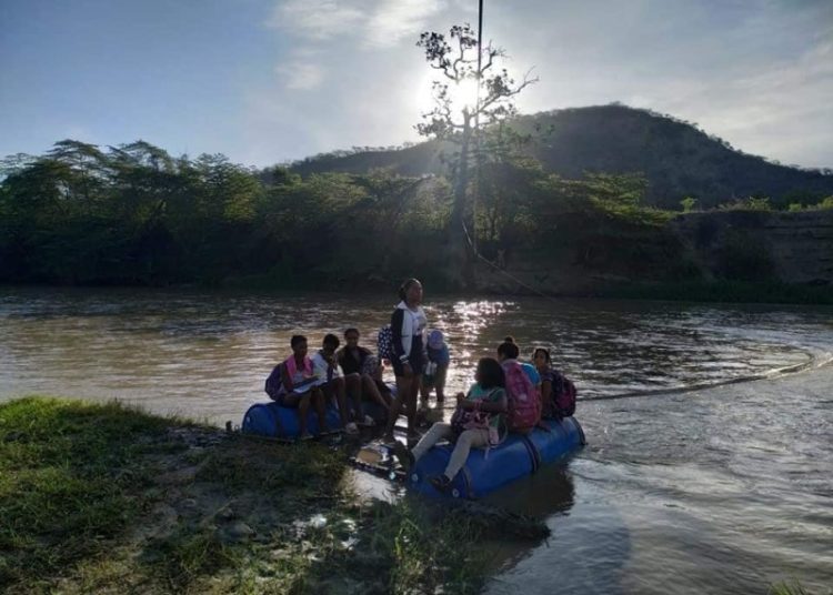 Estudiantes de Tamayo cruzan río Yaque del Sur en balsas para poder asistir a la escuela