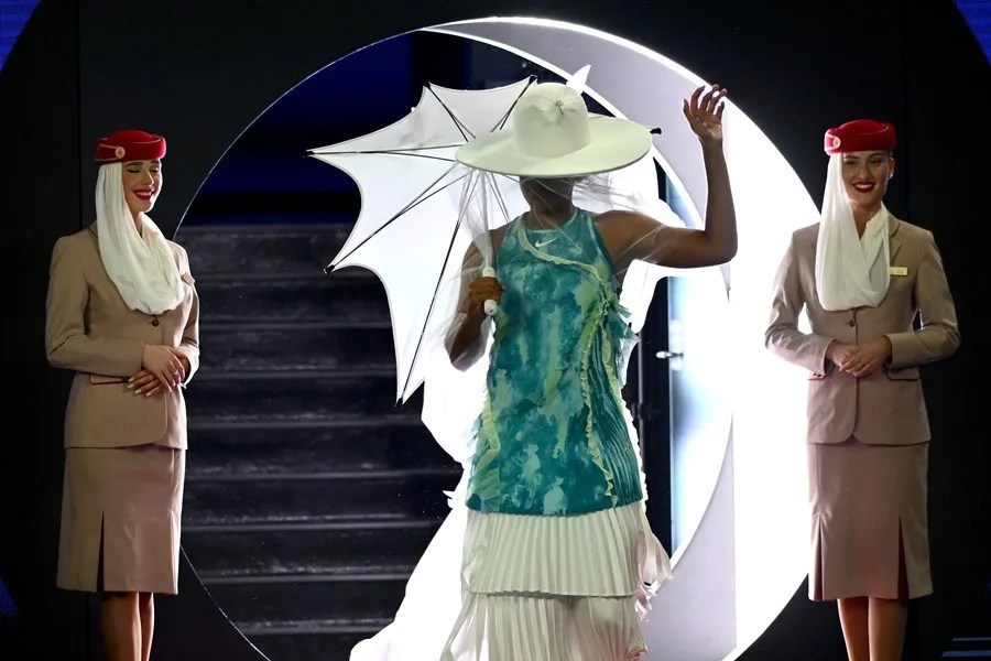 La tenista japonesa Naomi Osaka hace su entrada en pista con vestido largo, velo, sombrilla y sombrero, antes de su partido de hoy en el Abierto de Australia. 