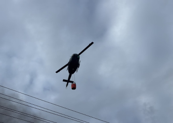 Helicóptero realiza descargas de agua para combatir incendio en L&R Comercial