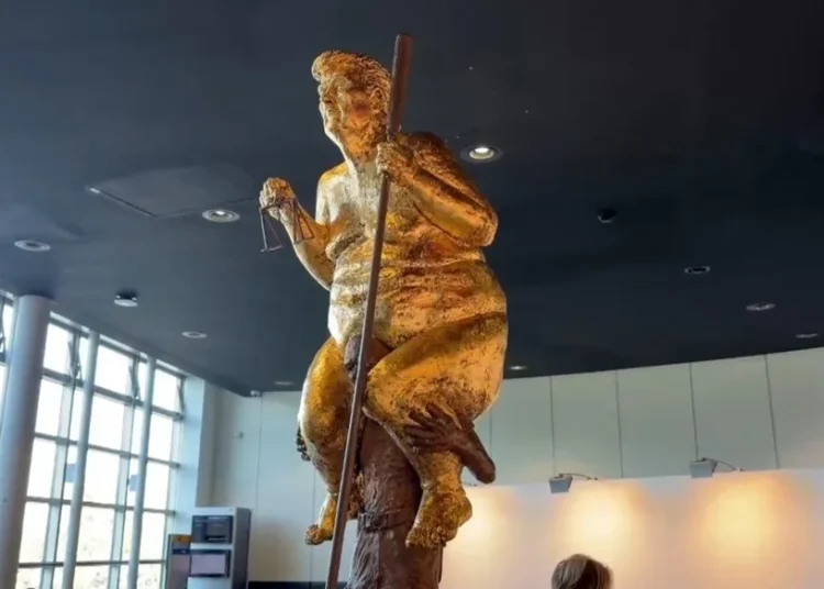 Una estatua dorada de Trump desnudo con un palo de golf sorprende al Parlamento Europeo